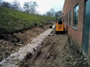 Excavator shaping new footpath formation during groundworks at York University Heslington Campus